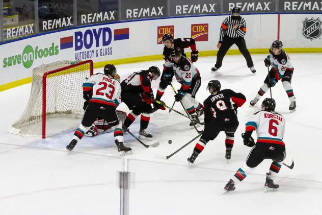 Kelowna Rockets try to control the puck in front of the Prince George Cougars net