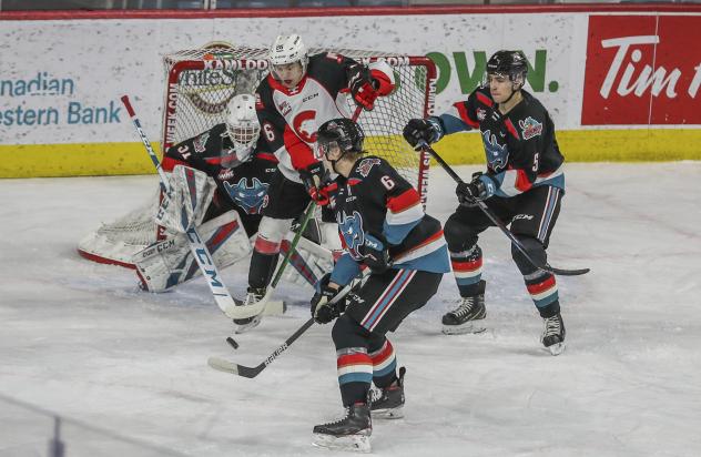 Prince George Cougars right wing Michael Svenson in a swarm of Kelowna Rockets