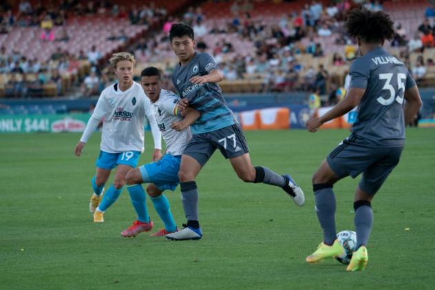 Tacoma Defiance midfielder Sota Kitahara (center) and defender Alex Villanueva (right) battle Las Vegas Lights FC