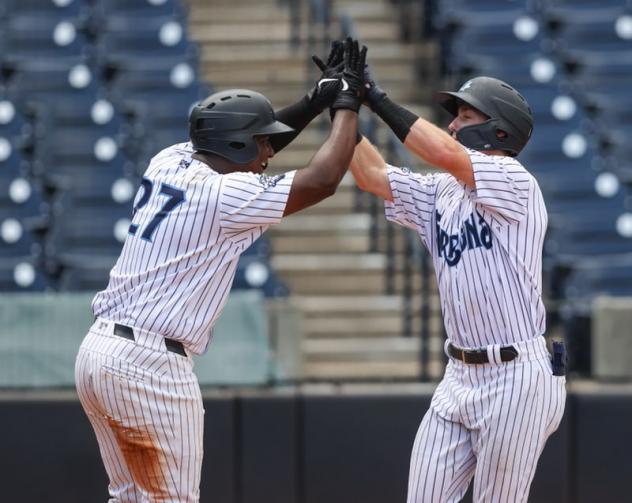 Juan De Leon congratulates Cooper Bowman after Bowman's grand slam for the Tampa Tarpons