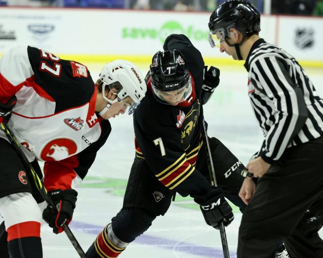 Vancouver Giants centre Ty Thorpe (right) faces off with the Prince George Cougars
