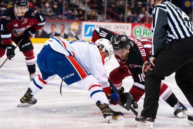 Vancouver Giants left wing Zack Ostapchuk (right) faces off with the Spokane Chiefs