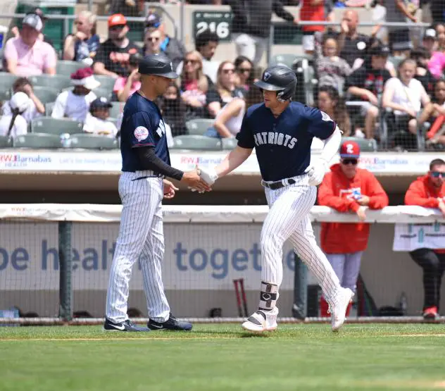 Josh Breaux of the Somerset Patriots receives a handshake following his home run