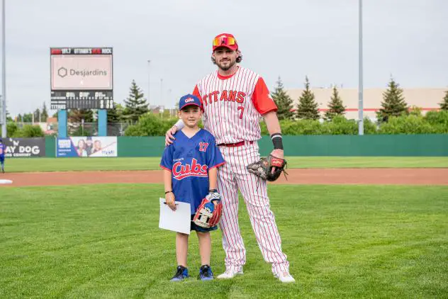 Ottawa Titans infielder A.J. Wright and a young fan