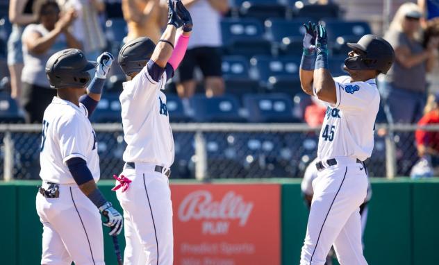 Kyle Lewis of the Everett AquaSox is greeted at home plate by Noelvi Marte and Alberto Rodriguez