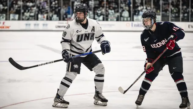 Eric MacAdams (left) skating for the University of New Hampshire
