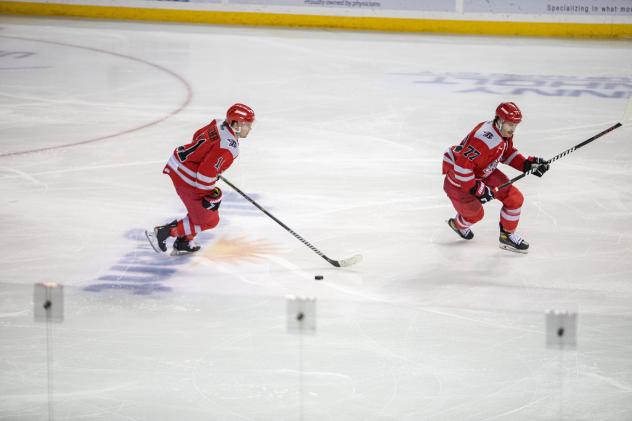Alec Butcher (left) skating with the puck for the Rapid City Rush