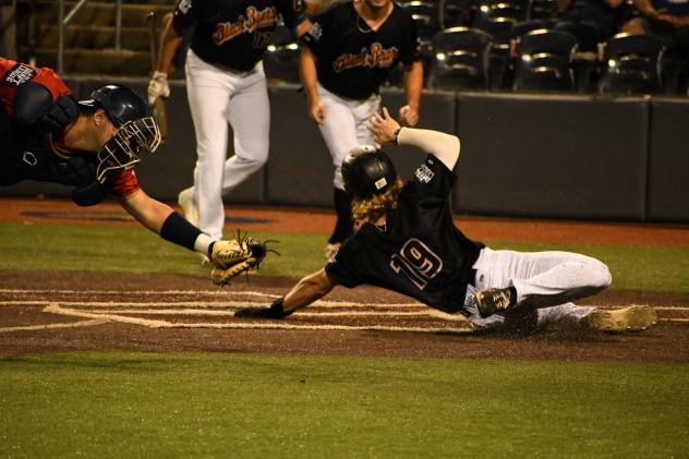 West Virginia Black Bears outfielder Maddux Houghton slides under the tag of Williamsport Crosscutters catcher Zach Miller