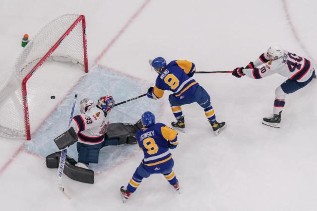 Saskatoon Blades' Brandon Lisowsky and Jayden Wiens battle Drew Sim and Parker Berge of the Regina Pats