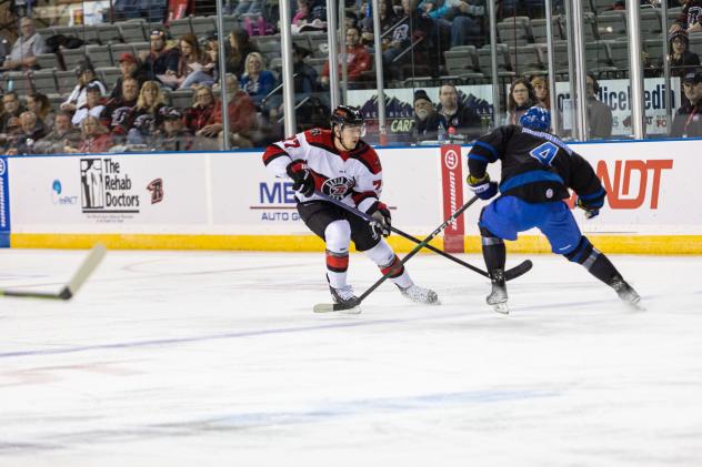 Rapid City Rush defenseman Simon Lavigne (center)