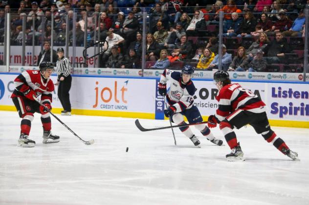 Saginaw Spirit's 	Sebastien Gervais battles Ottawa 67's Frankie Marrelli and Chris Barlas