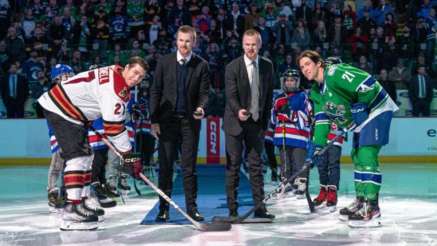 Tucson Roadrunners' Adam Cracknell and Abbotsford Canucks' Chase Wouters with Vancouver Canucks legends Daniel and Henrik Sedin