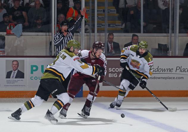 Peterborough Petes' Quinton Pagé battles North Bay Battalion's Avery Winslow and Pasquale Zito