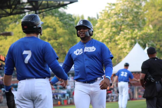 Evansville Otters exchange congratulations following a home run