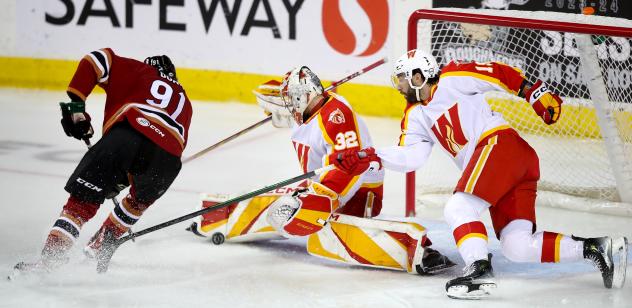 Tucson Roadrunners' Josh Doan battles Calg' ary Wranglers' Dustin Wolf