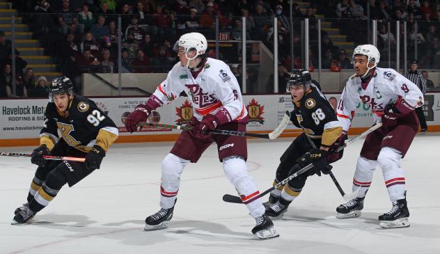 Peterborough Petes' Konnor Smith and Donovan McCoy and Kingston Frontenacs' Matthew Soto and Jacob Battaglia in action