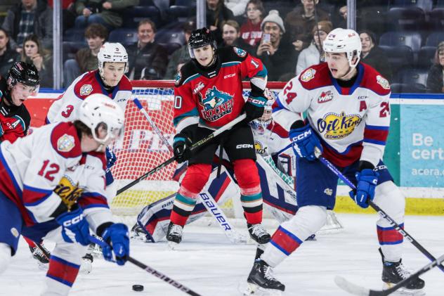 Kelowna Rockets' Luke Schelter and Edmonton Oil Kings' John Szabo, Blake Fiddler, and Marc Lajoie on the ice