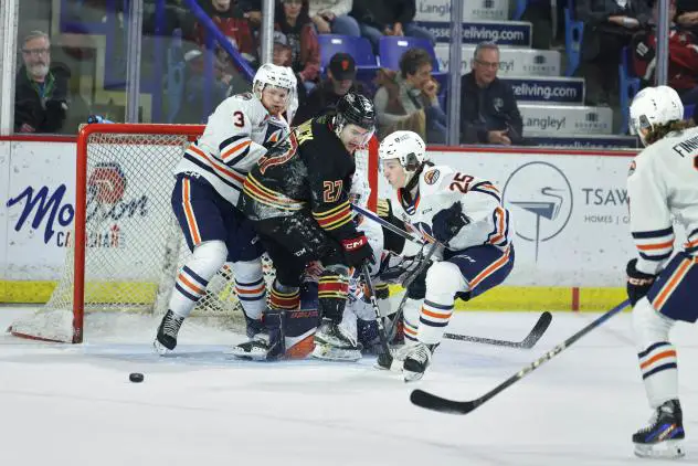 Vancouver Giants' Kyren Gronick battles Victoria Royals' Justin Kipkie and Reggie Newman
