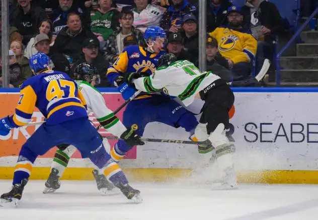 Saskatoon Blades' Charlie Wright and Prince Albert Raiders' Cole Peardon in action