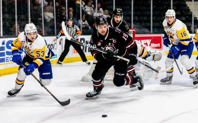 Red Deer Rebels' Kai Uchacz and Saskatoon Blades' Nicholas Andrusiak and Fraser Minten in action