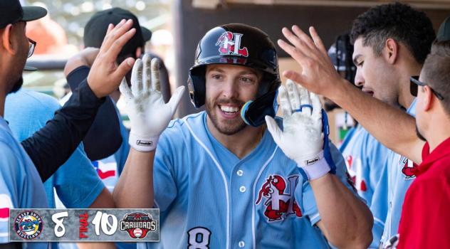 Tucker Mitchell receives congratulations in the Hickory Crawdads dugout