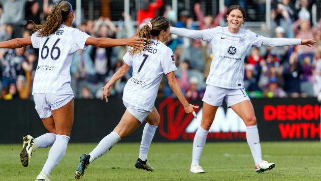 Racing Louisville's Reilyn Turner (66) and Savannah DeMelo (7) rush to congratulate Emma Sears