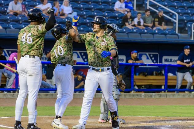 Biloxi Shuckers' Brock Wilken congratulated by Ernesto Martinez Jr. and Carlos D. Rodriguez