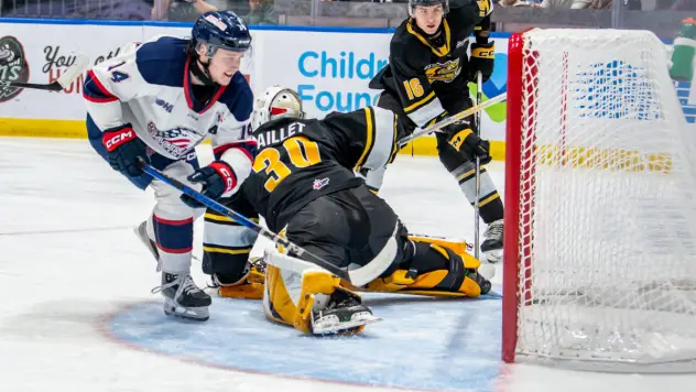 Saginaw Spirit's Joey Willis battles Sarnia Sting's Evan Maillet and James Barr