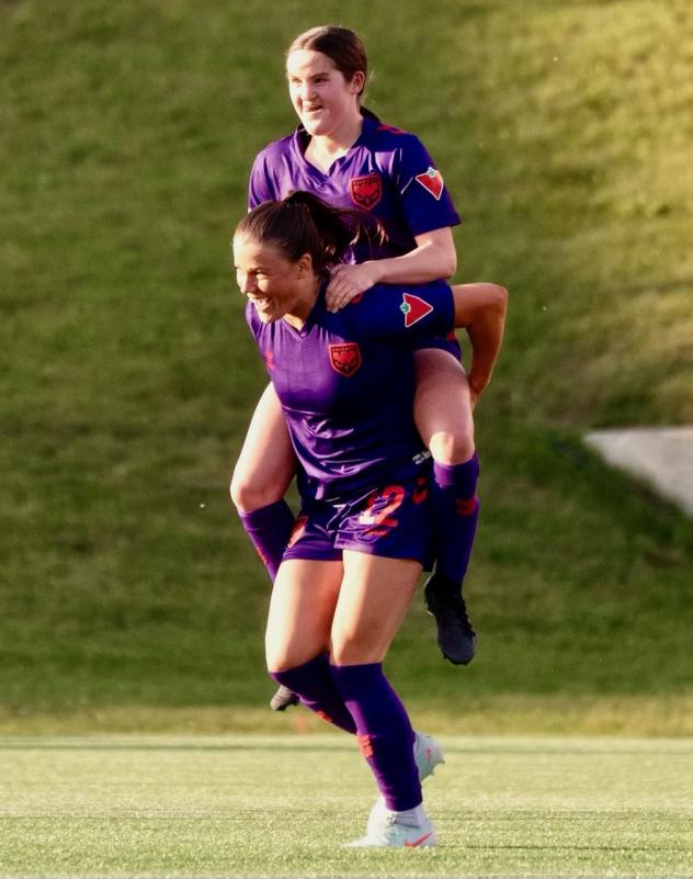Calgary Wild FC celebrate a Taegan Stewart (top) goal