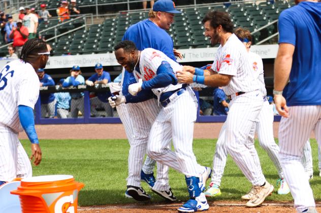 Luis De Los Santos of the Syracuse Mets greeted by his teammates