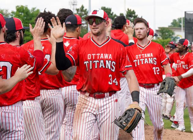 Ottawa Titans outfielder Jake Sanford exchanges high fives