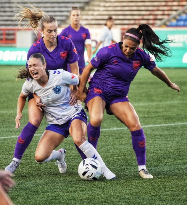 Calgary Wild FC fight to take the ball against Ottawa Rapid FC