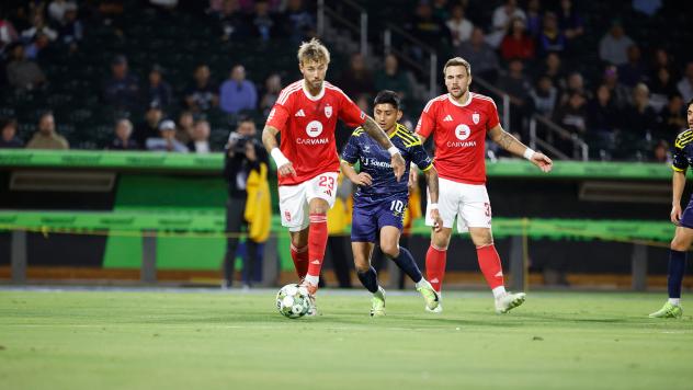 Phoenix Rising's Ryan Flood and Rafael Czichos and El Paso Locomotive FC's Amando Moreno on the field