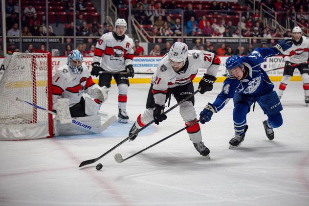 Syracuse Crunch center Tristan Allard (right) lunges for a puck vs. the Charlotte Checkers