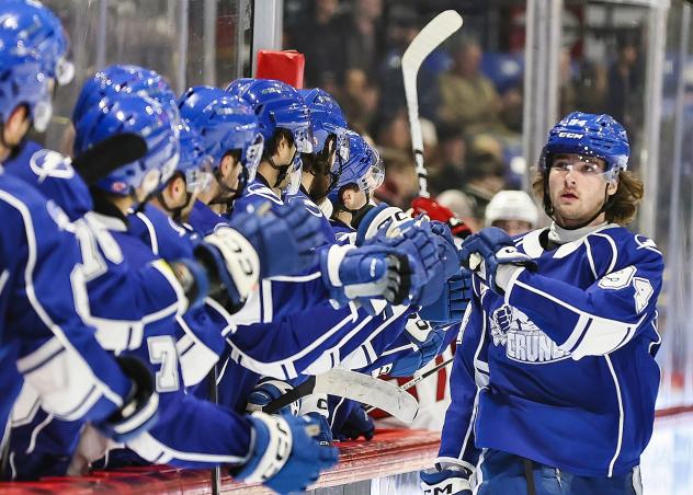 Syracuse Crunch center Conor Geekie receives congratulations from the bench