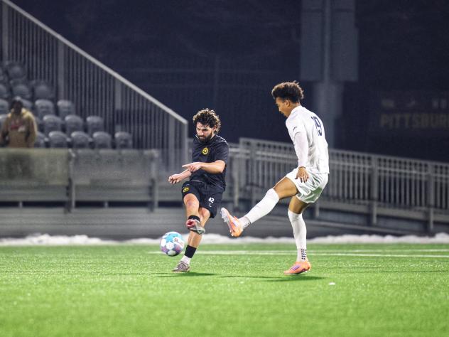 Pittsburgh Riverhounds midfielder Jackson Walti (left) vs. Duquesne University