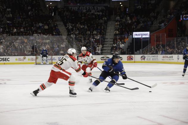 Grand Rapids Griffins left wing Dylan James (left) reaches for the puck against the Cleveland Monsters