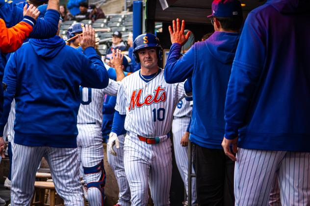 A.J. Ewing is congratulated in the Syracuse Mets dugout