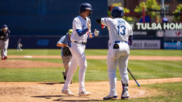 Kyle Nevin of the Tulsa Drillers (right) high fives Zyhir Hope