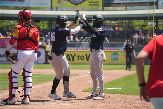 Tyler Hardman of the Somerset Patriots is congratulated at home plate