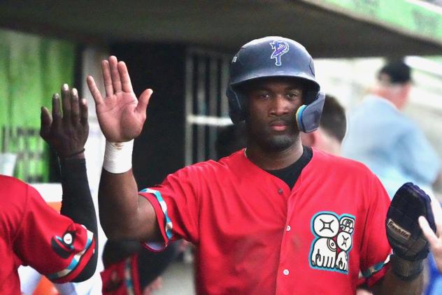 Pensacola Blue Wahoos exchange congratulations in the dugout