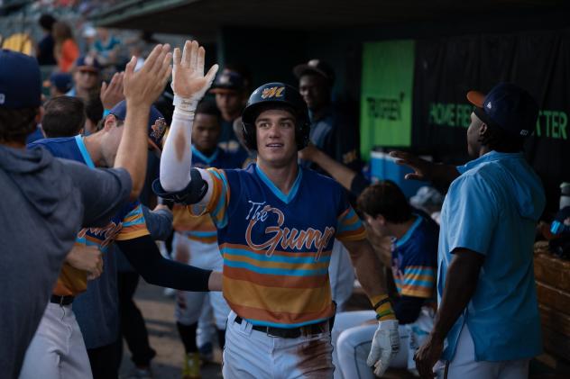 Austin Overn of the Montgomery Biscuits receives congratulations in the dugout