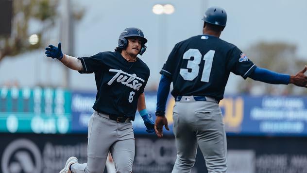 Tulsa Drillers' bench coach Johan Garcia congratulates Jake Gelof as he rounds the bases