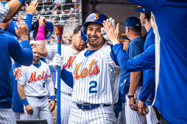 Matt Rudick is congratulated by Syracuse Mets teammates in the dugout