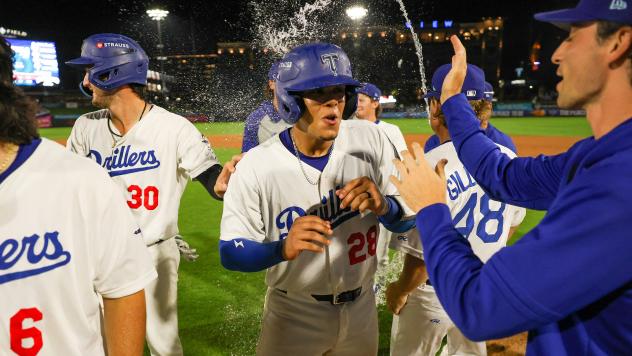 Frank Rodriguez of the Tulsa Drillers is greeted after scoring the winning run