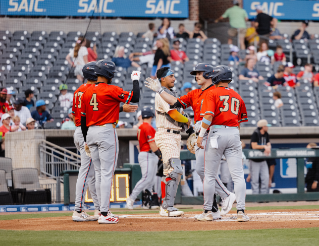 Pensacola Blue Wahoos exchange congratulations at home plate