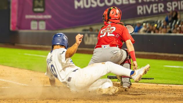 Taylor Young of the Tulsa Drillers slides safely into home plate