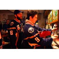 Allan McPherson pours a beer as Zach Cohen looks on