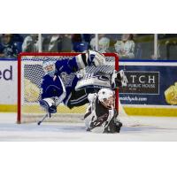 Victoria Royals Goaltender Griffen Outhouse is upended by Tyler Benson of the Vancouver Giants
