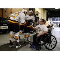 Scooter Vaughan of the Chicago Wolves greets young fan Blake Burriss